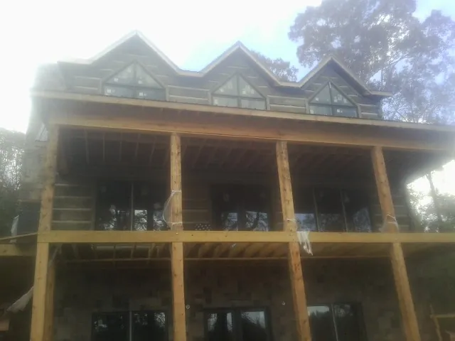 Dormers and porch framing on a large log home under construction — Roof Coating work by our crew in Port Jervis