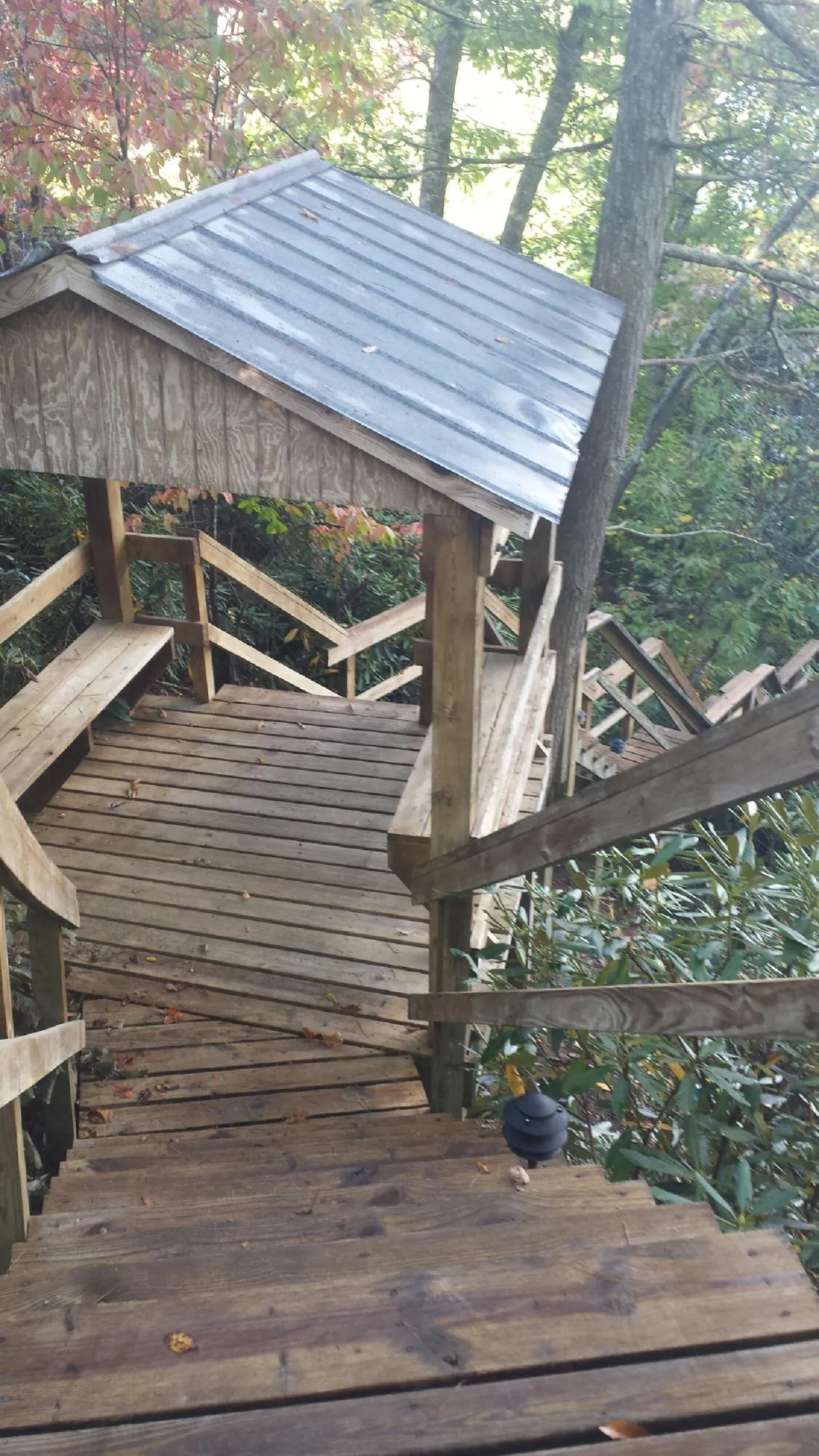 Metal roofed shelter over wooden steps on a wooded walkway — Skylight Repair & Installation work by our crew in Port Jervis