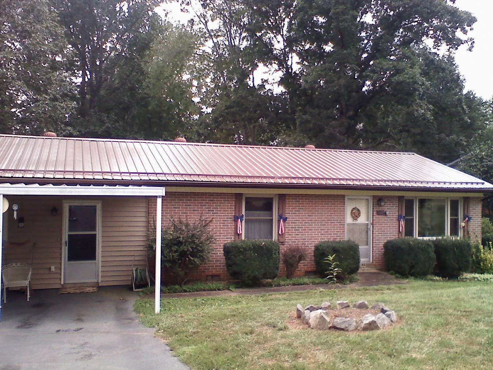 Bronze metal roof and carport on a brick ranch home — Roof Repair work by our crew in Port Jervis